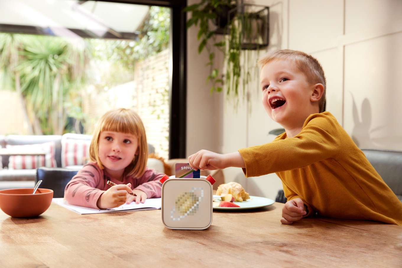 children sitting at the table with an interactive audio player 